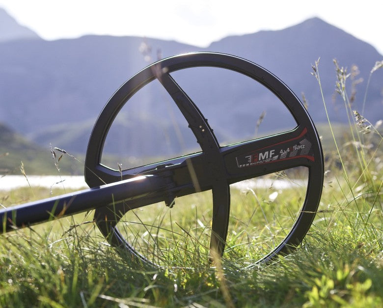 XP 11 inch FMF search coil on a Deus II resting in mountain meadow grass
