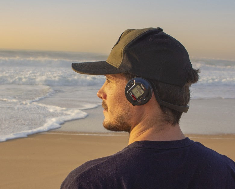 Detectorist wearing XP WS6 ST wireless headphones on a beach