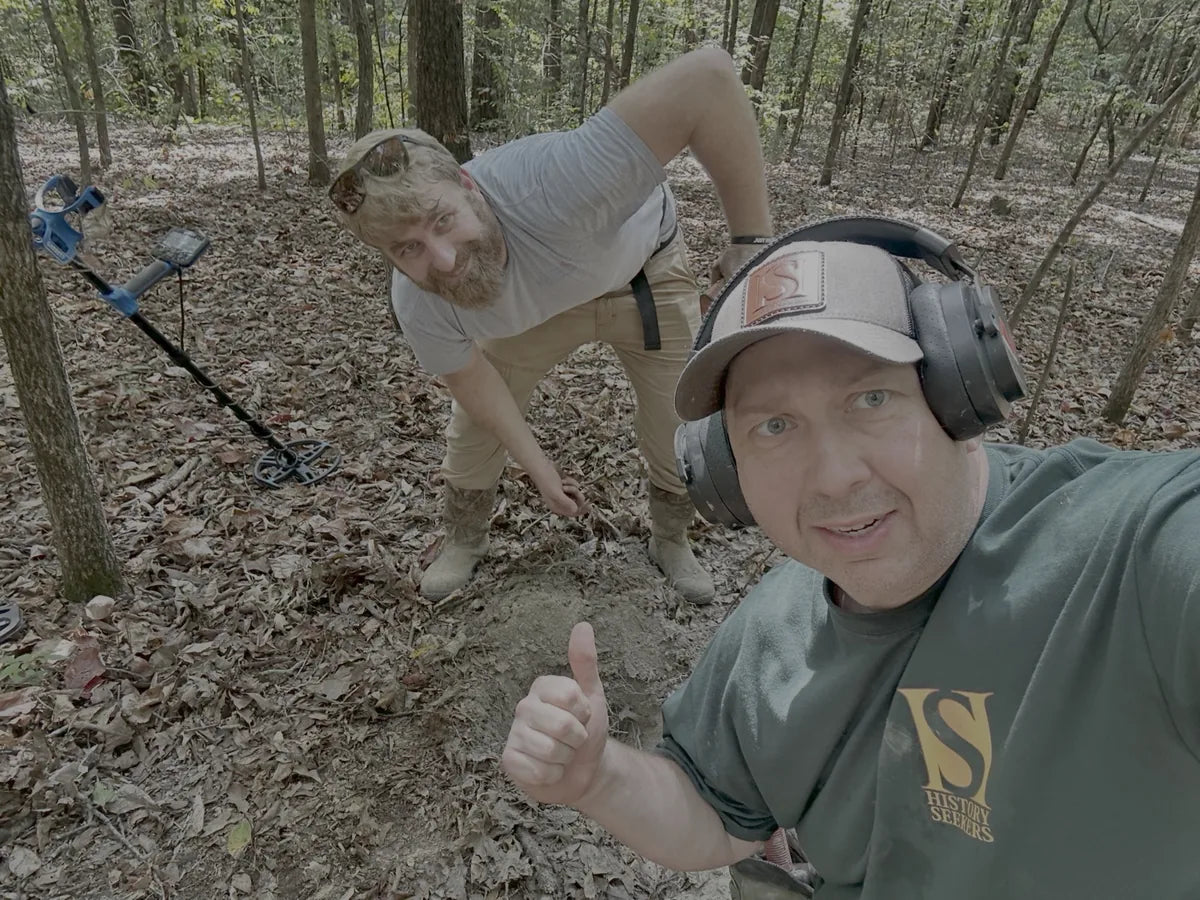 Detectorist metal detecting in wooded terrain with a Garrett Vortex VX9