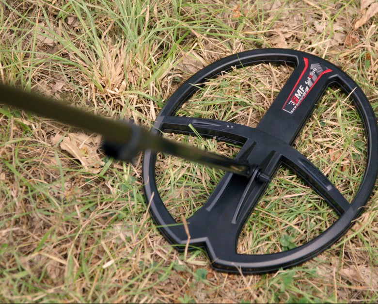Top-down view of the XP 13x11 inch elliptical FMF coil on a Deus II over dry grass