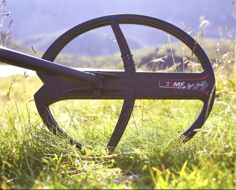 XP 13x11 inch elliptical FMF search coil on a Deus II in sunlit meadow grass